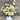 pink and green flowers arrangement in a white hat box against a dark wall designed in Mount Waverley