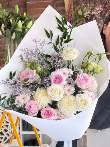 Bouquet of flowers with white and pink roses on a white paper background.