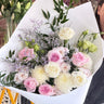 Bouquet of flowers with white and pink roses on a white paper background.